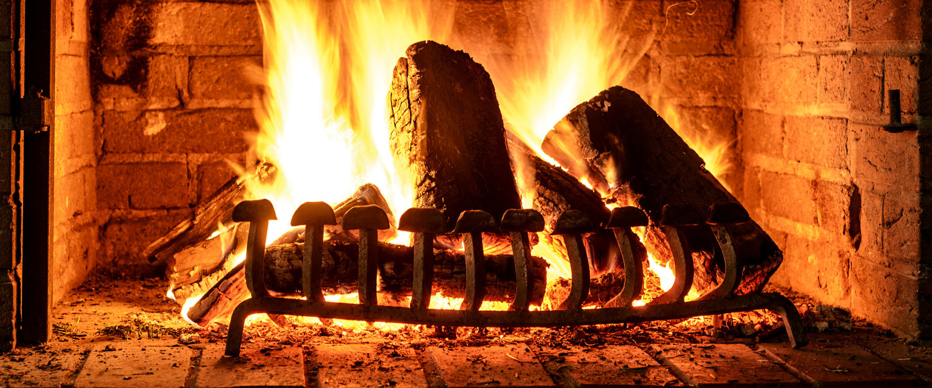 Why are woodburning stoves more efficient than open fireplaces?